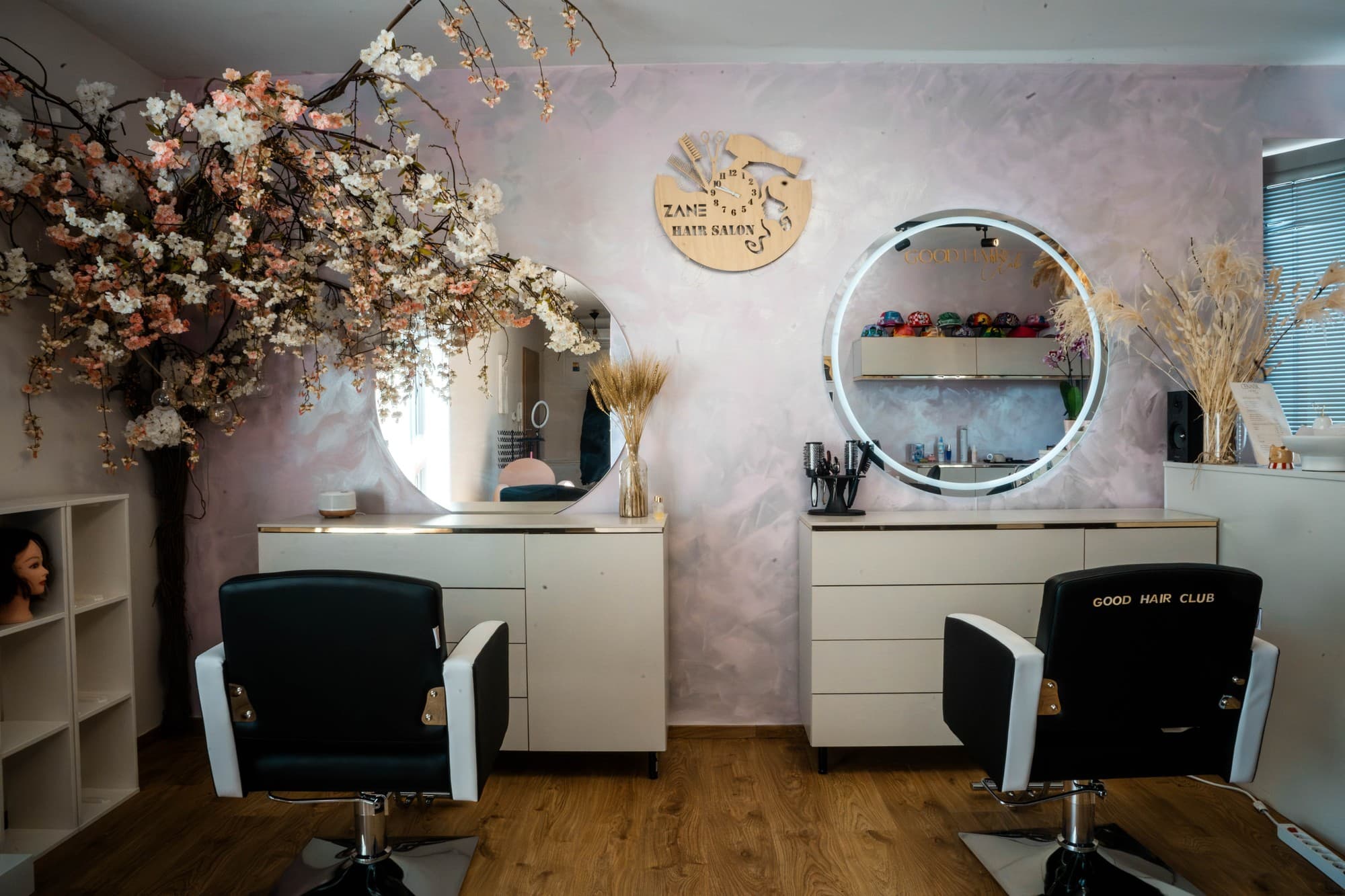 Interiér vlasového salónu Good Hair by Zane v Ivanke pri Dunaji — kadernícke stanice s osvetlenými zrkadlami a kvetinovými dekoráciami