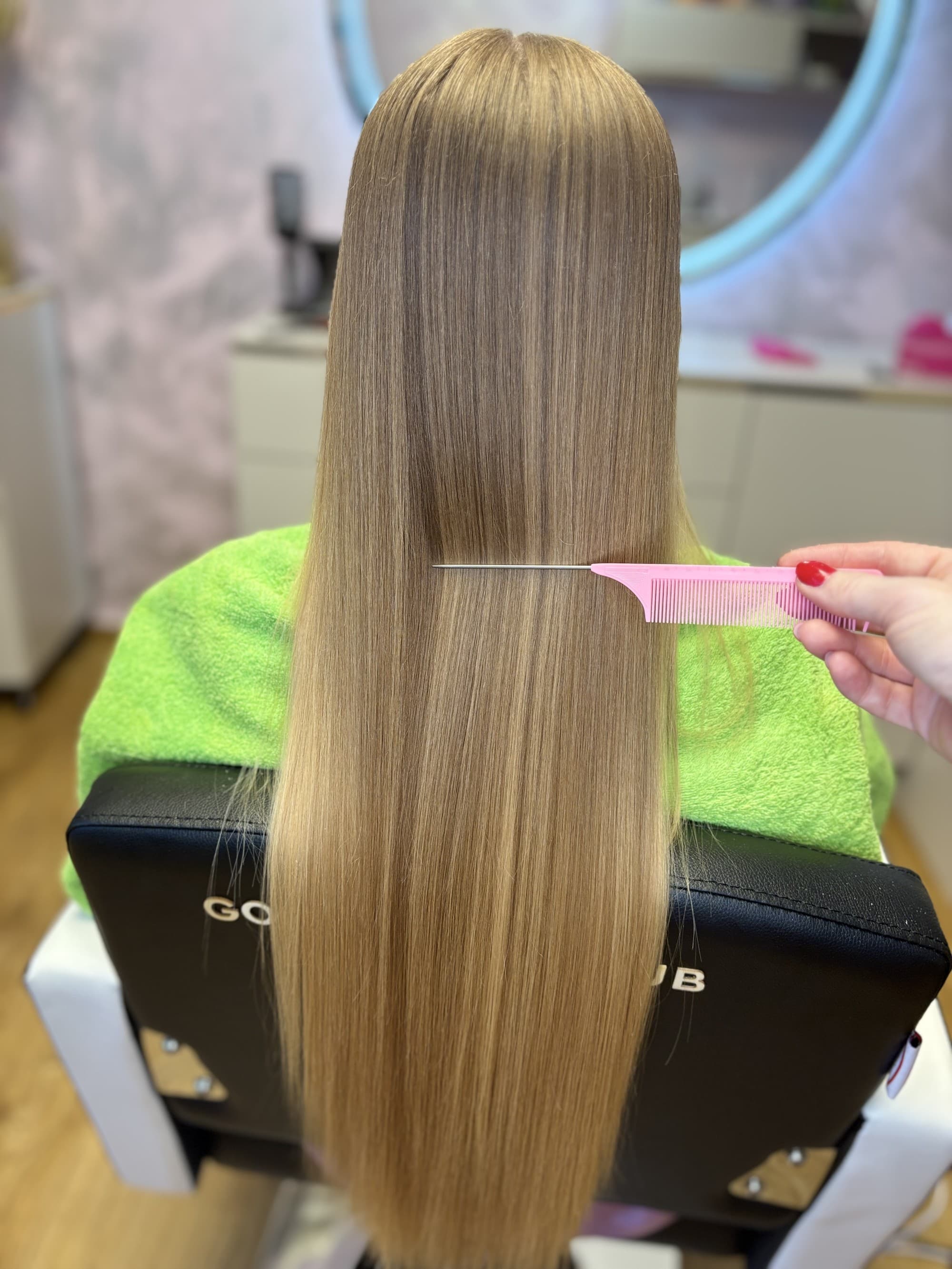 Kadernícke stanice v salóne Good Hair by Zane — dve pracovné miesta so zrkadlami a kvetinovými dekoráciami